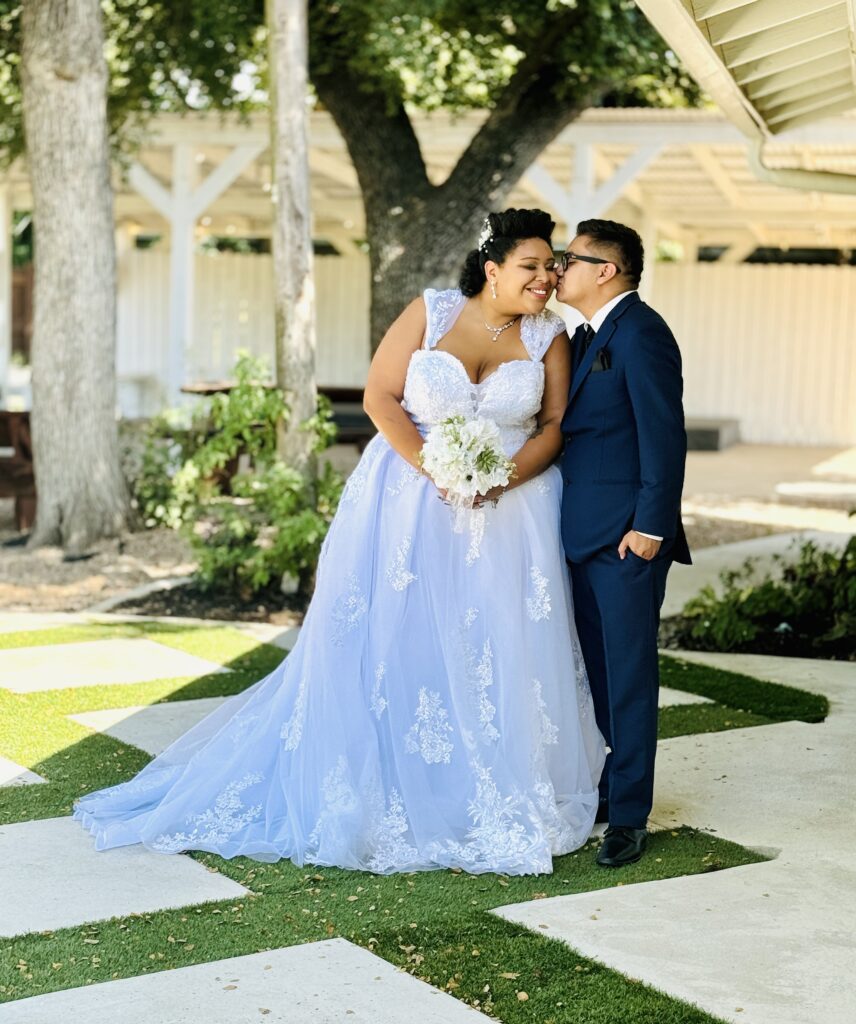 bride and groom kissing on antique rose veranda, austin wedding venue, dripping springs, texas hill country, affordable wedding venue