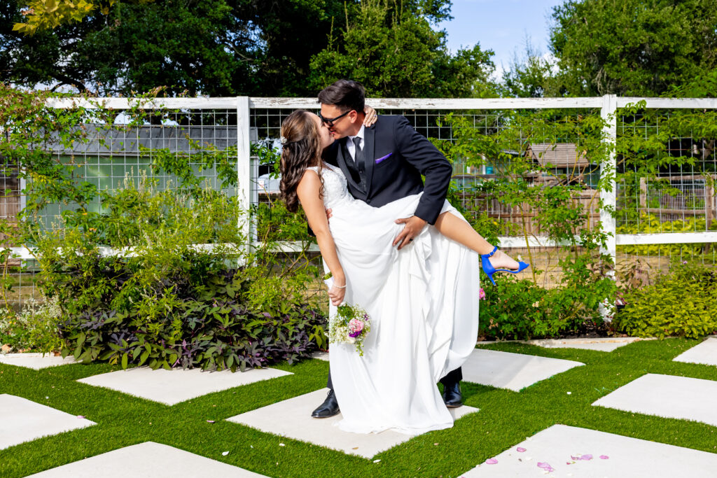 michael and emily share a fun dip and kiss after their wedding ceremony, austin wedding venue, austin wedding reception venue, austin bride, austin wedding, affordable wedding venue, budget friendly wedding venue, cheap wedding venue in Austin, dripping springs wedding venue, dripping springs venue, texas hill country,